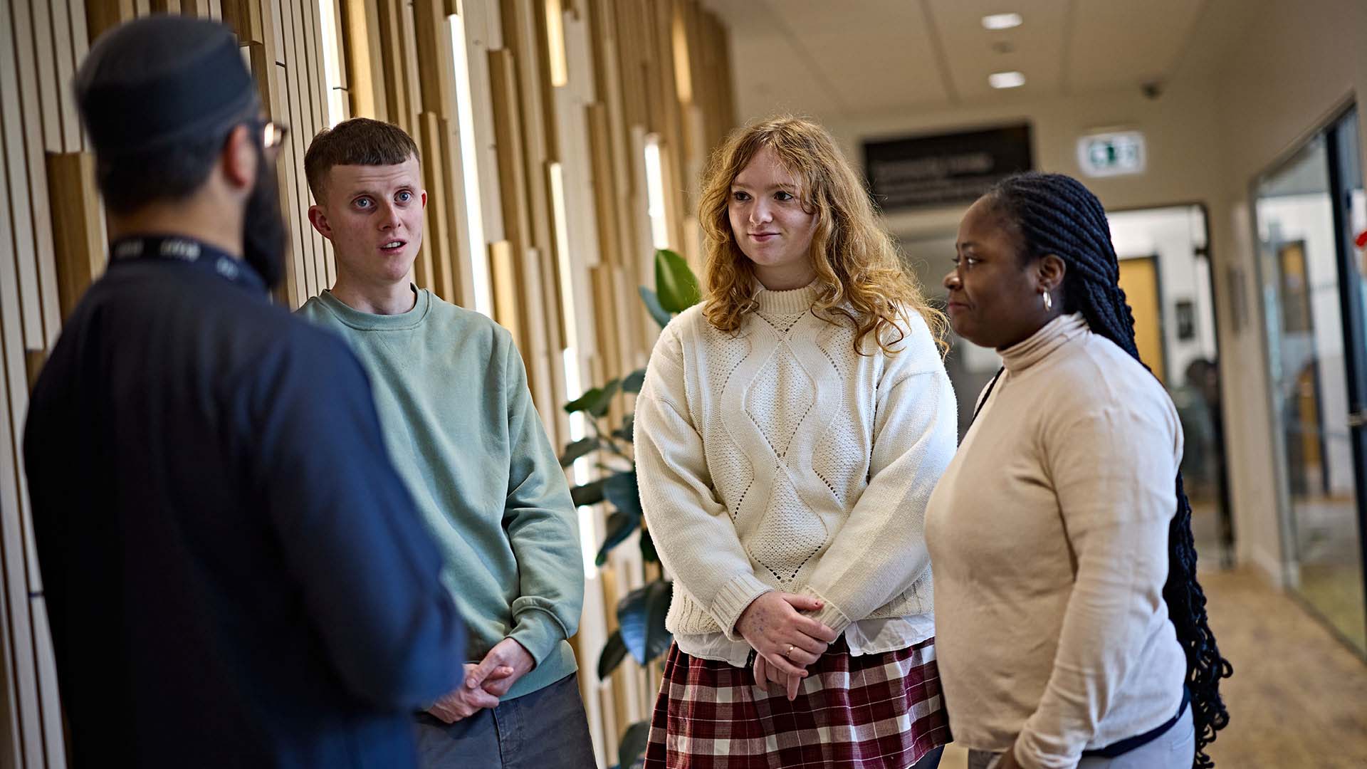 Students stood in the corridor talking to the Muslim Chaplain.